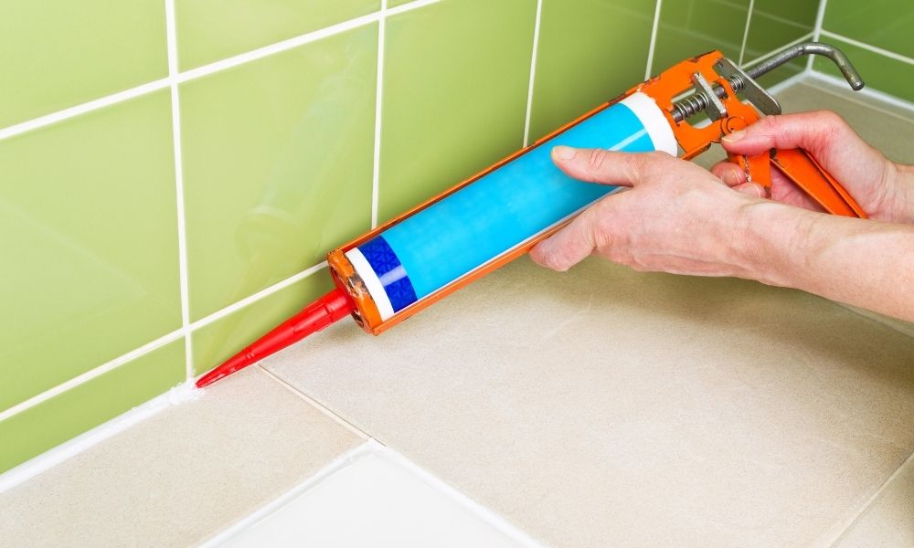 sealing shower tiles with caulk gun